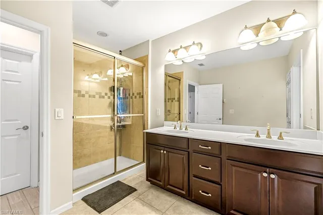 a bathroom with a double vanity sink and mirror with shower