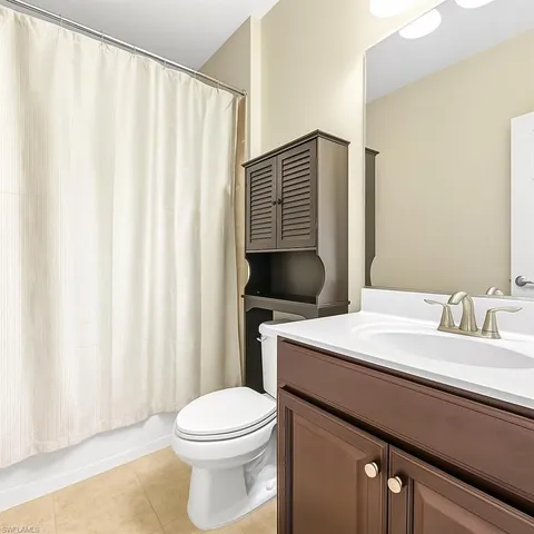 a bathroom with a sink a toilet and shower curtain