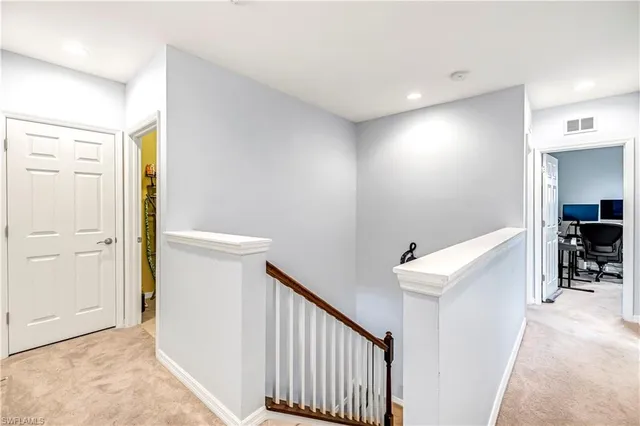 a view of hallway with furniture and a refrigerator