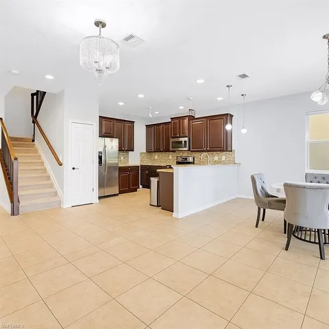 a view of kitchen with stainless steel appliances granite countertop living room and microwave