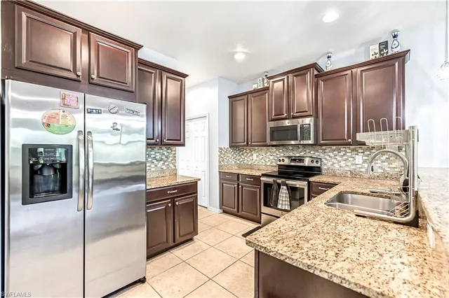 a kitchen with granite countertop stainless steel appliances and wooden cabinets