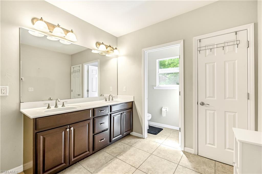 19550 Bowring Park Road, Unit 102 Fort Myers, FL 33967 - Photo 10 of 20 a spacious bathroom with a double vanity sink a large mirror and a bathtub