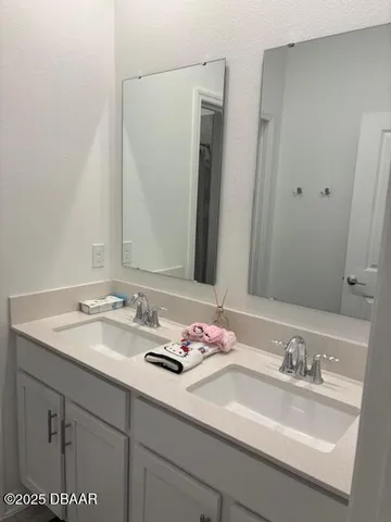 a bathroom with double sink and a mirror