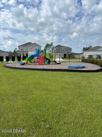 a view of swimming pool with lawn chairs and large trees
