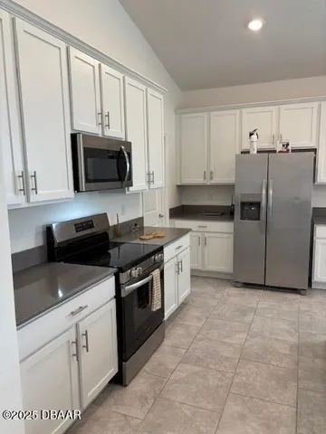 a kitchen with cabinets stainless steel appliances and a counter space