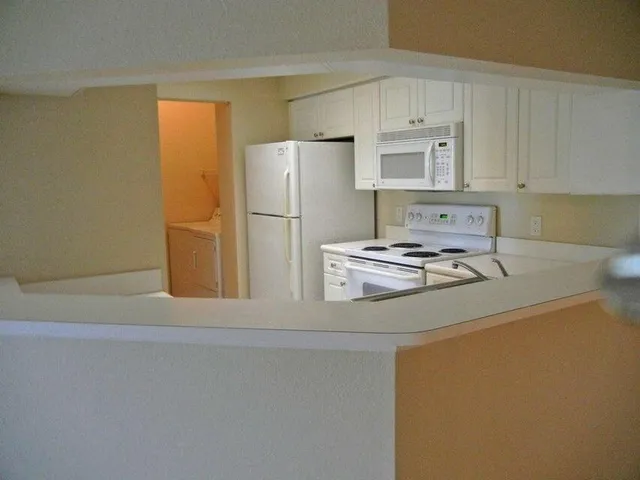 a kitchen with a refrigerator sink stove and cabinets