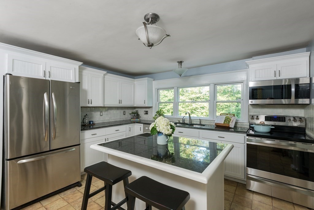 7 Longfellow Road Winchester, MA 01890 - Photo 18 of 42 a kitchen with a refrigerator a stove a microwave and island with wooden floor