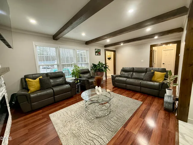 a living room with furniture a fireplace and a chandelier
