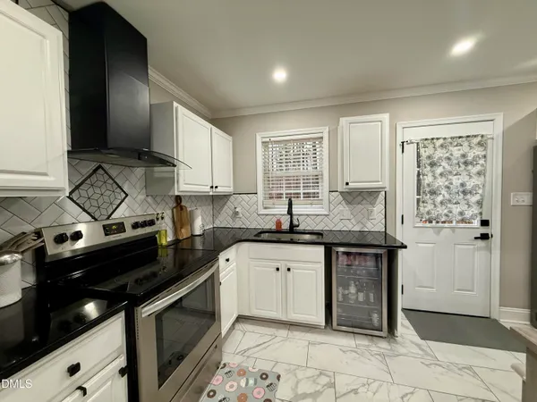 a kitchen with stainless steel appliances granite countertop white cabinets sink and stove