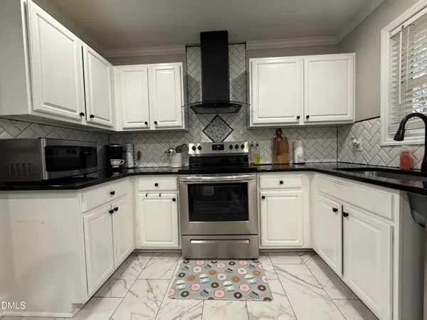 a kitchen with granite countertop a sink a counter top space cabinets and stainless steel appliances