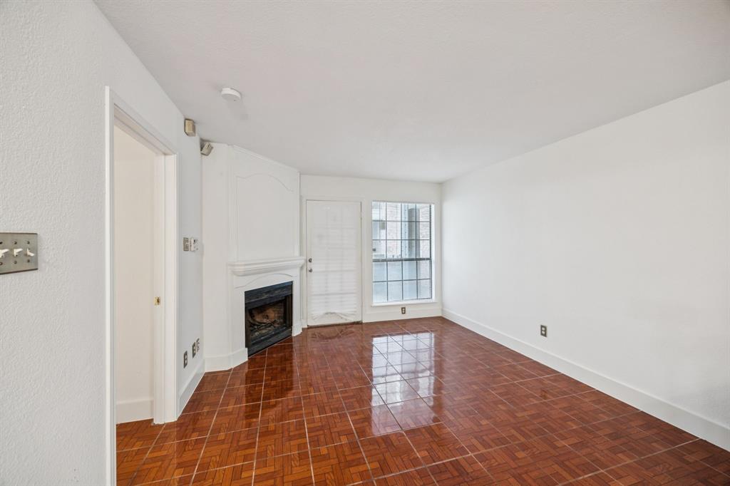 6108 Abrams Road, Unit 410 Dallas, TX 75231 - Photo 3 of 10 a view of an empty room with a fireplace