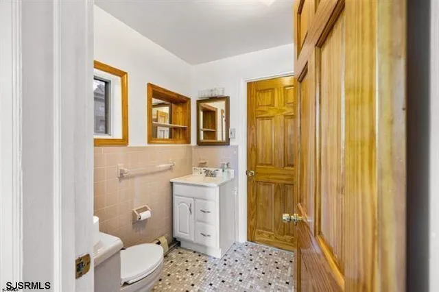 a bathroom with a granite countertop sink toilet and shower curtains