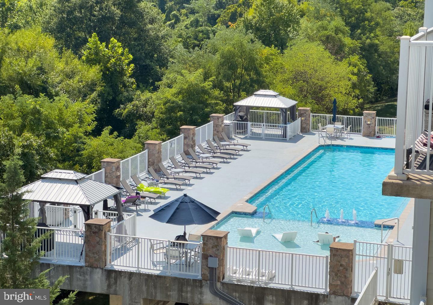 6301 Edsall Road, Unit 123 Alexandria, VA 22312 - Photo 32 of 36 Serene poolside retreat amidst lush greenery.