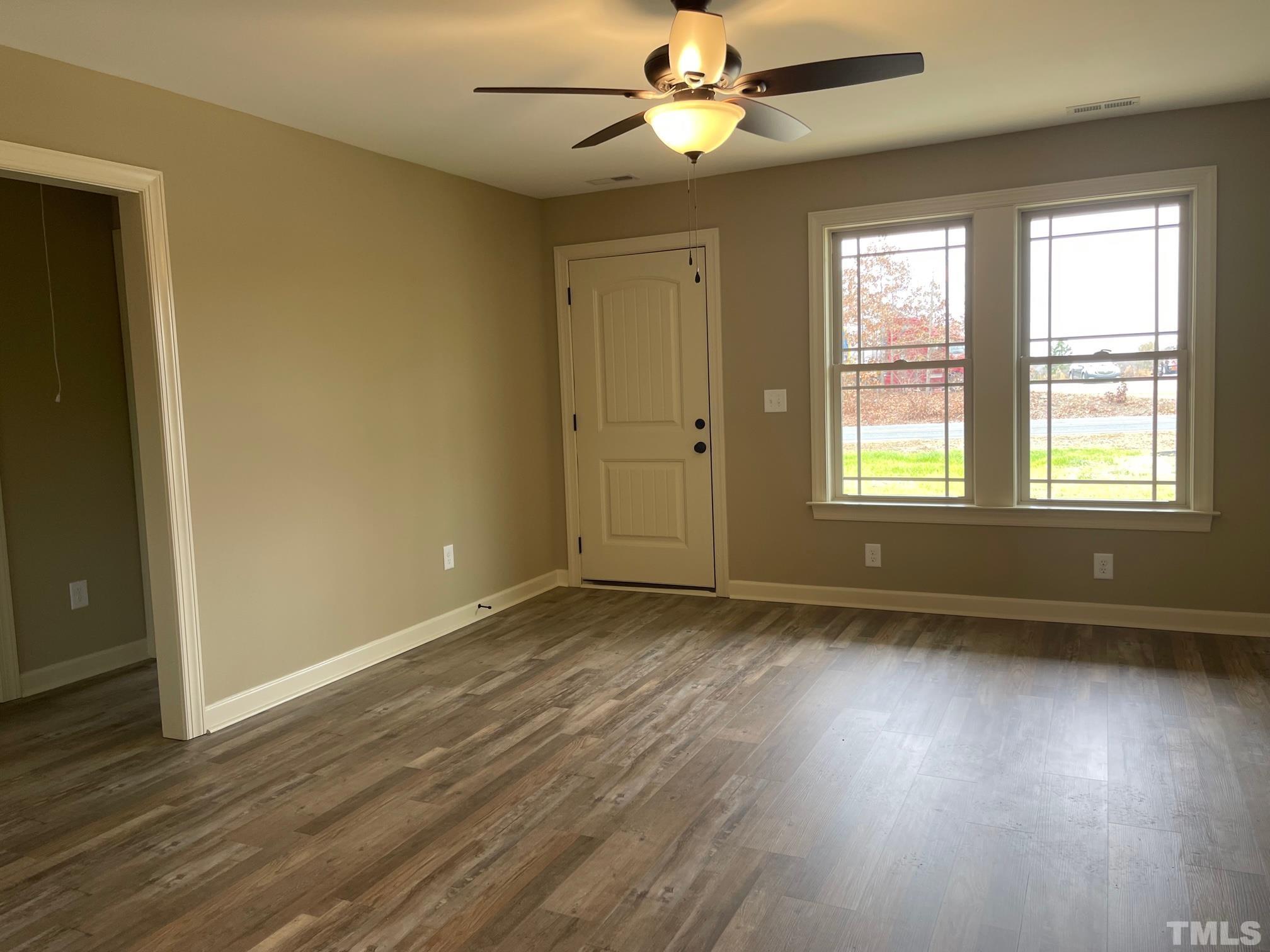 675 Bethel Church Road Angier, NC 27501 - Photo 3 of 23 a view of an empty room with wooden floor and a window