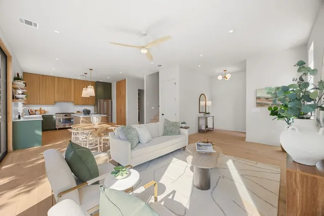 a living room with furniture dining area and a chandelier