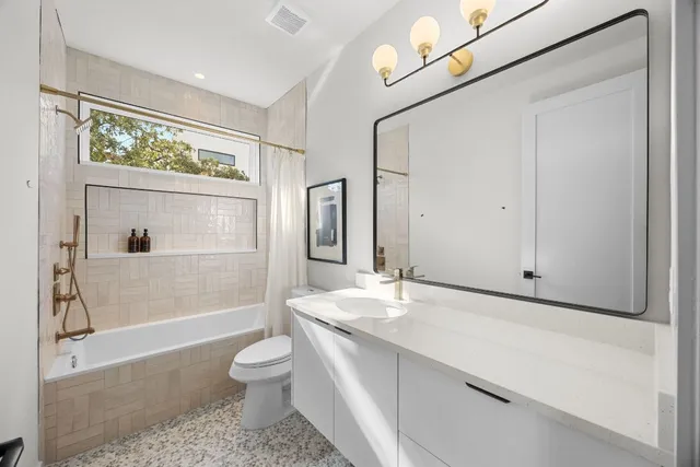 a bathroom with a granite countertop sink toilet a large mirror a vanity and shower