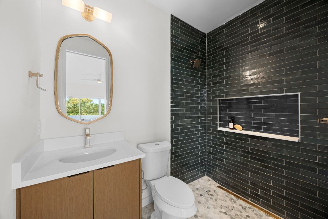 1175 Navasota Street, Unit 2 Austin, TX 78702 - Photo 31 of 40 a bathroom with a toilet sink and mirror