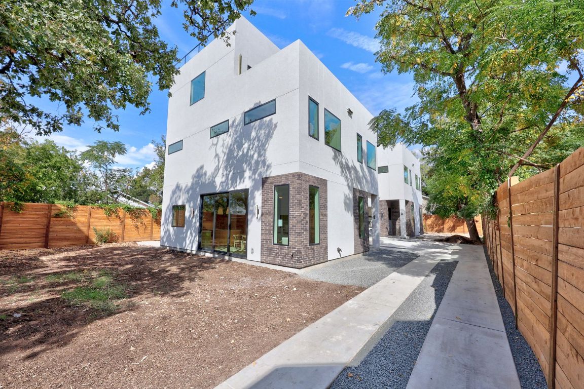 1175 Navasota Street, Unit 2 Austin, TX 78702 - Photo 4 of 40 a view of a white building among the street with palm trees