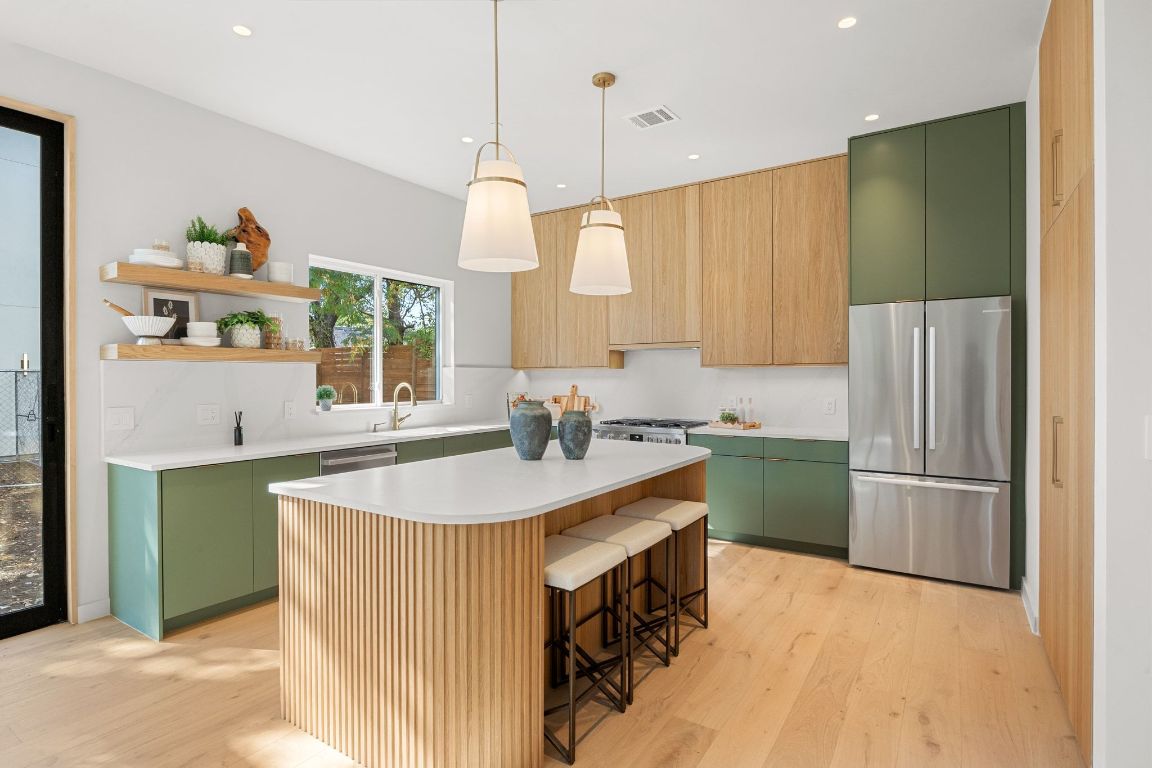 1175 Navasota Street, Unit 2 Austin, TX 78702 - Photo 6 of 40 a kitchen with kitchen island a sink appliances and a counter top space