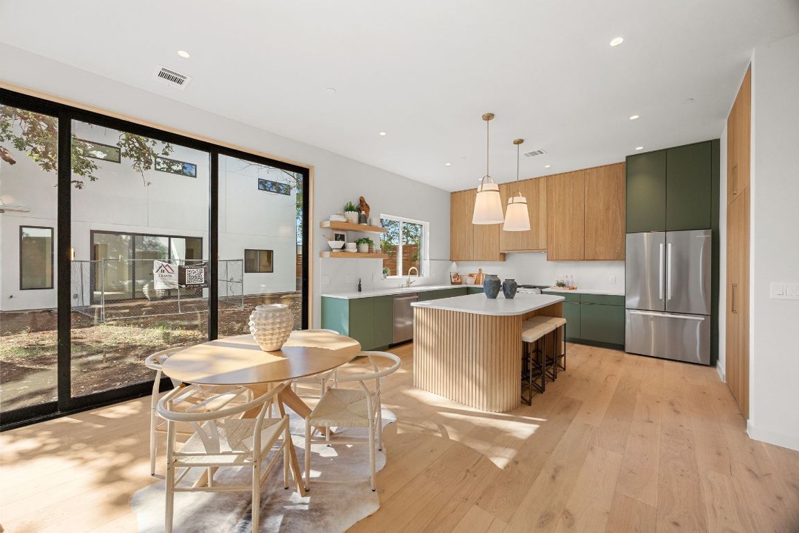 1175 Navasota Street, Unit 2 Austin, TX 78702 - Photo 8 of 40 a large kitchen with kitchen island a large counter top space a sink stainless steel appliances and cabinets
