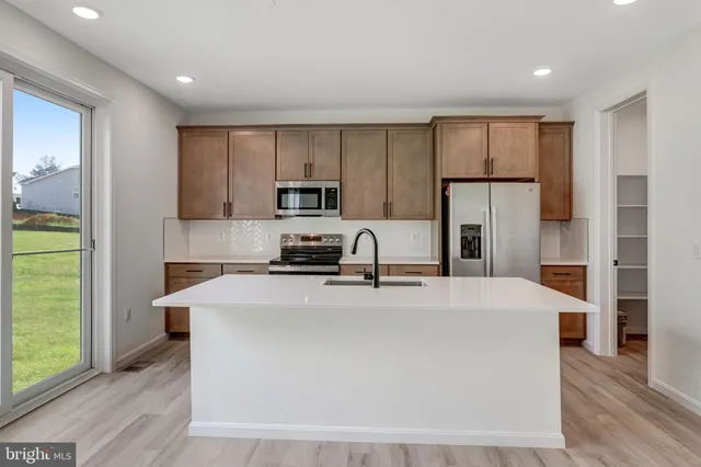 a kitchen with stainless steel appliances a refrigerator sink and microwave