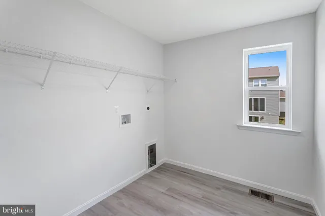 a view of a small space with wooden floor and a window