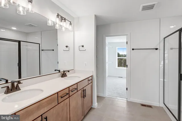 a bathroom with double vanity sinks and a mirror