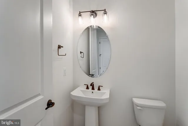 a bathroom with a sink and mirror with toilet
