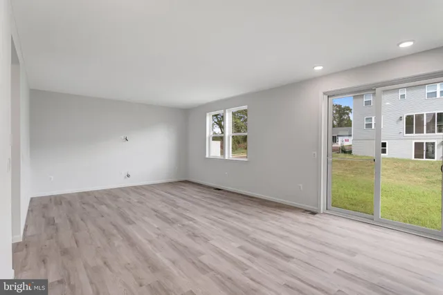 a view of a big room with wooden floor and windows