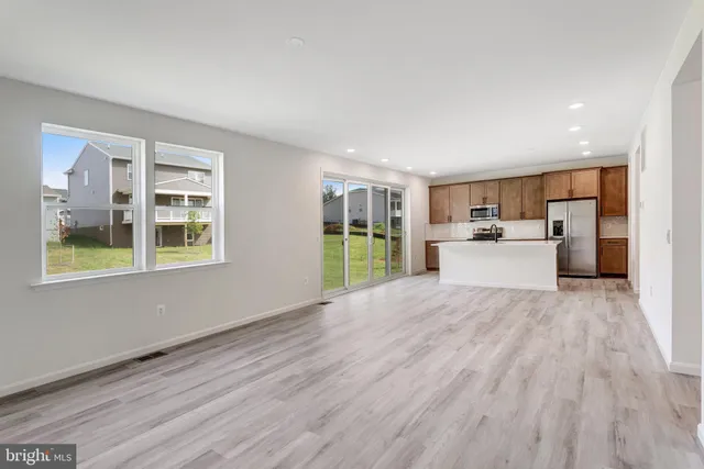 a view of empty room with wooden floor and windows