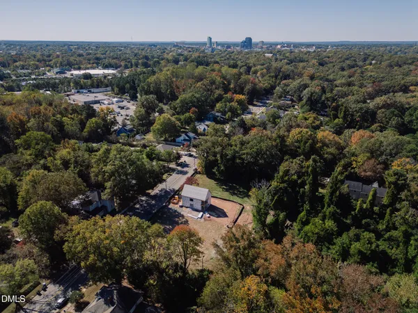 an aerial view of residential house with outdoor space and trees all around