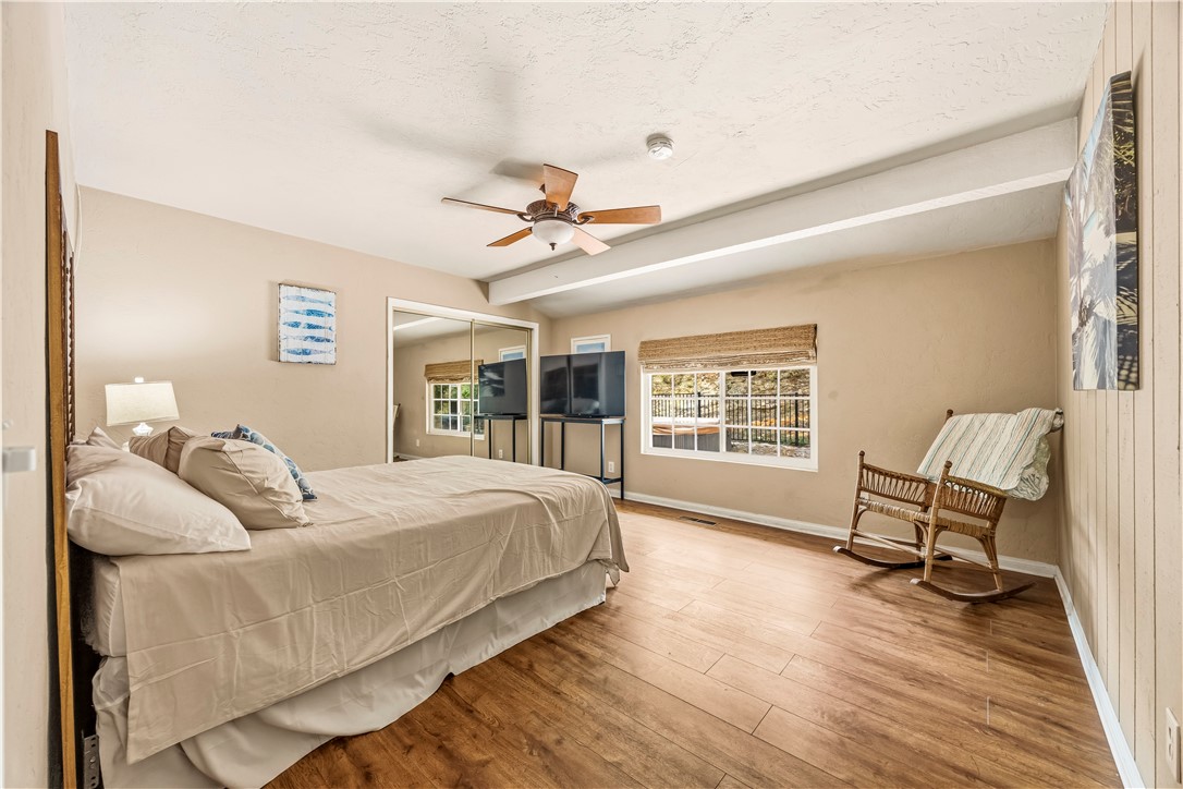 1485 Vía Ladera Fallbrook, CA 92028 - Photo 28 of 43 a bedroom with a bed wooden floor and a large window