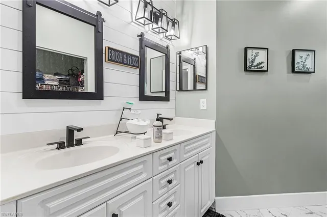 a bathroom with double vanity sink and a mirror