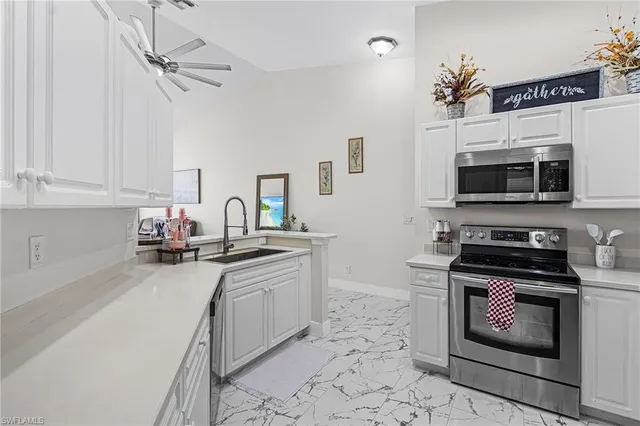 a kitchen with stainless steel appliances a stove sink microwave and cabinets