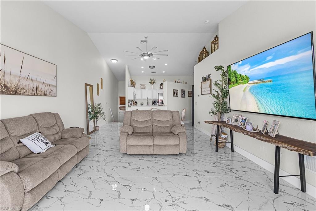 25110 Peacock Lane, Unit 201 Naples, FL 34114 - Photo 8 of 24 a living room with furniture a rug and a flat screen tv