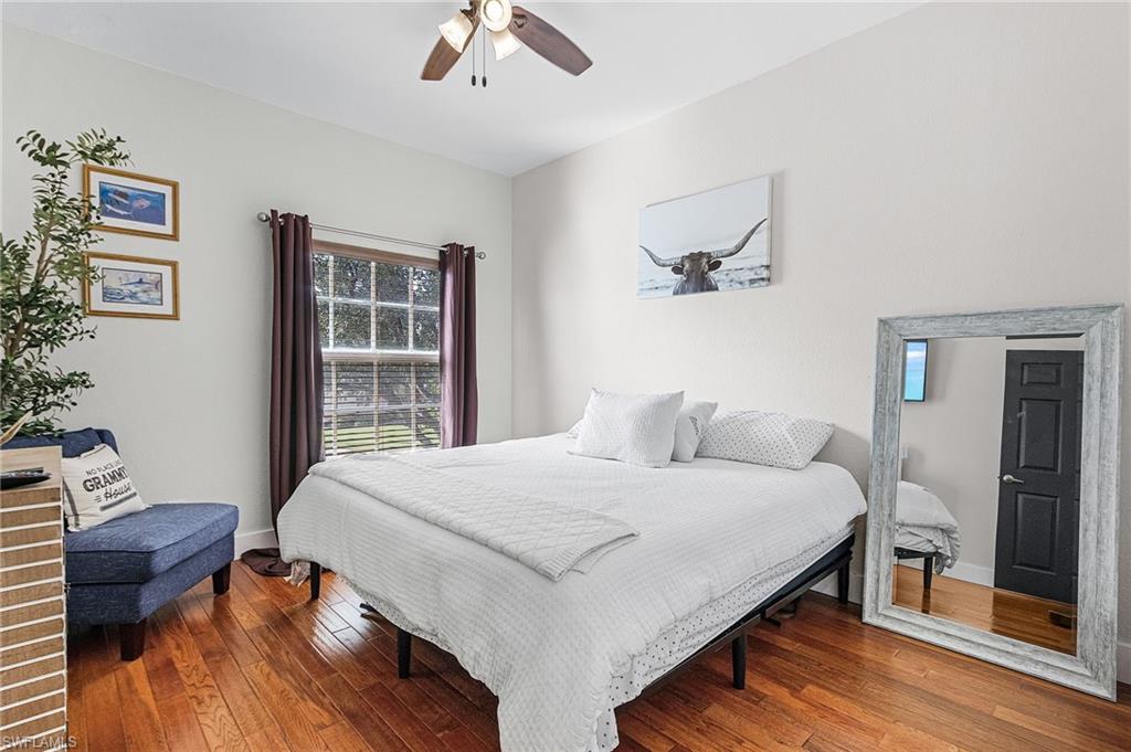 25110 Peacock Lane, Unit 201 Naples, FL 34114 - Photo 10 of 24 a bedroom with a bed and wooden floor