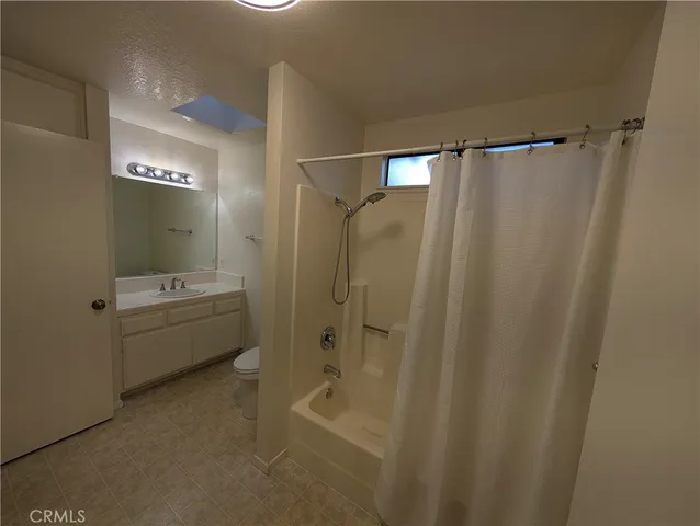 a bathroom with a shower a sink and a toilet