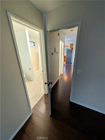 a view of a hallway with wooden floor and stairs