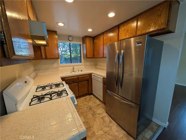 a kitchen with stainless steel appliances a refrigerator sink and stove