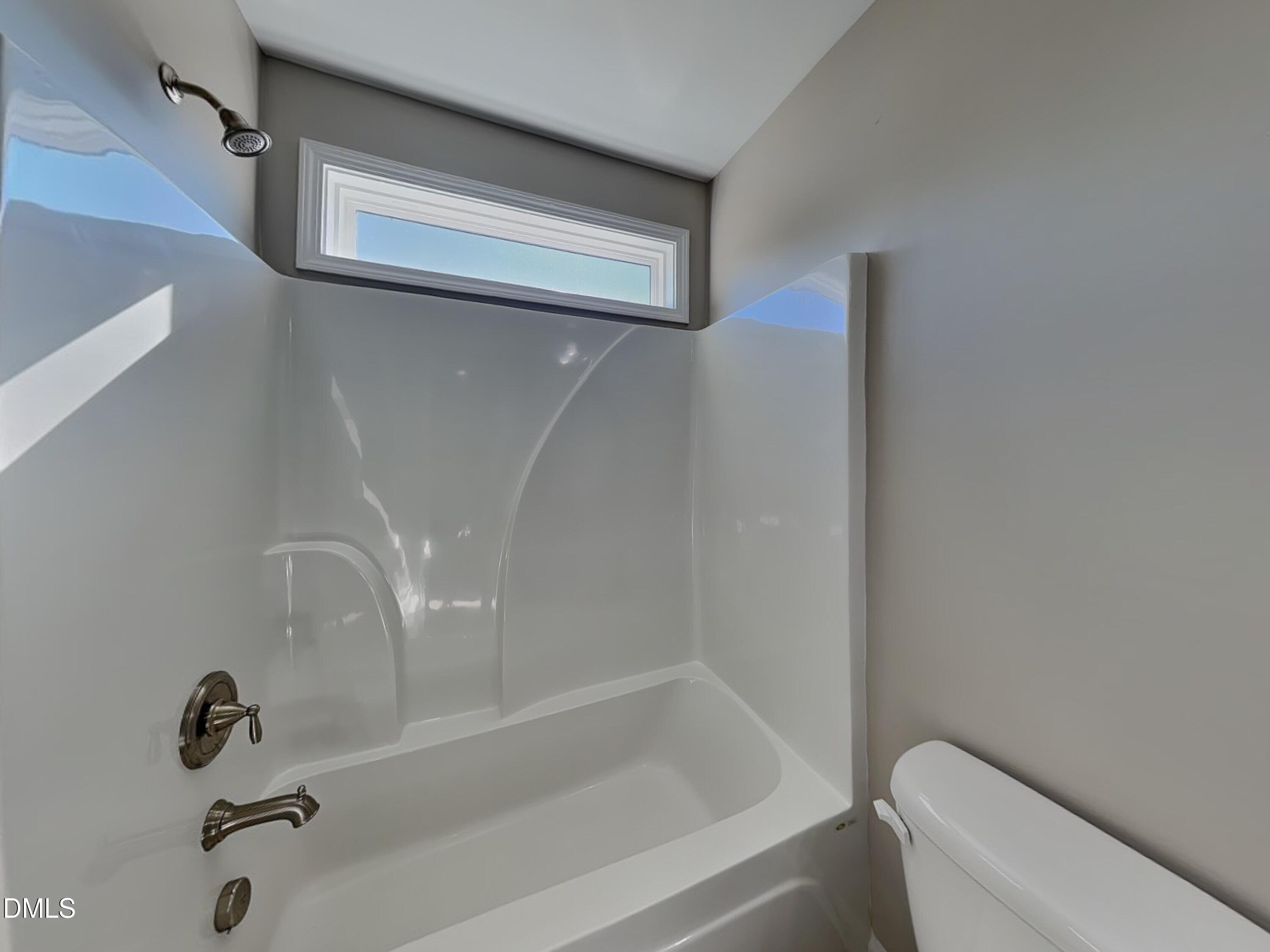 376 Olde Place Zebulon, NC 27597 - Photo 14 of 15 a bathroom with a bathtub