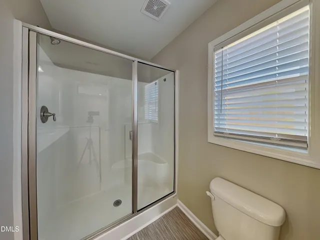 a bathroom with a shower and toilet