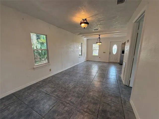 a view of an empty room with a window and a fireplace