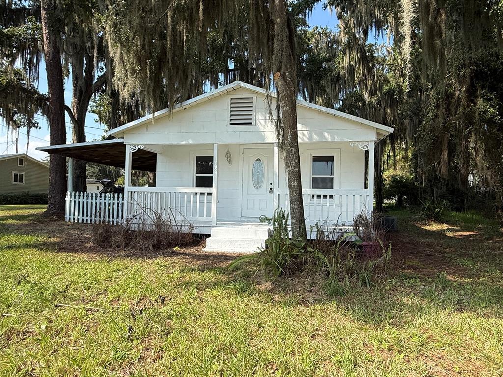 102 Possum Hollow Road Georgetown, FL 32139 - Photo 2 of 24 a view of a small yard in front of a house with large trees and plants