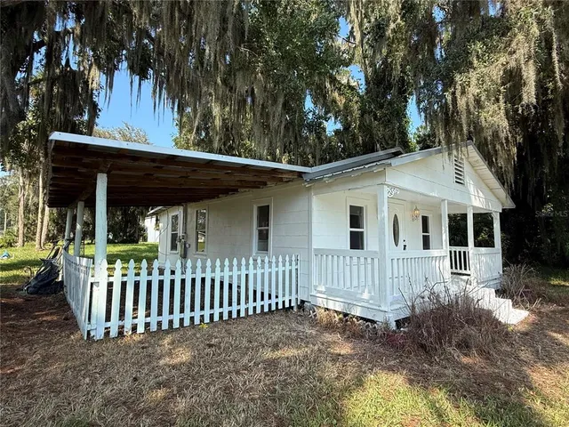 a view of a house with a small yard and wooden fence