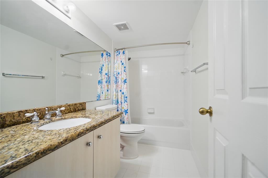 11133 Southwest 8th Street, Unit 306 Pembroke Pines, FL 33025 - Photo 11 of 14 a bathroom with a granite countertop sink a toilet and shower