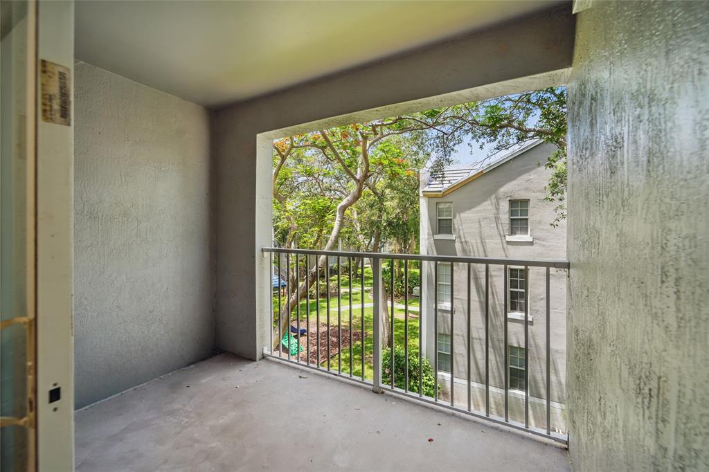 11133 Southwest 8th Street, Unit 306 Pembroke Pines, FL 33025 - Photo 13 of 14 a view of a porch with a floor to ceiling window and wooden fence