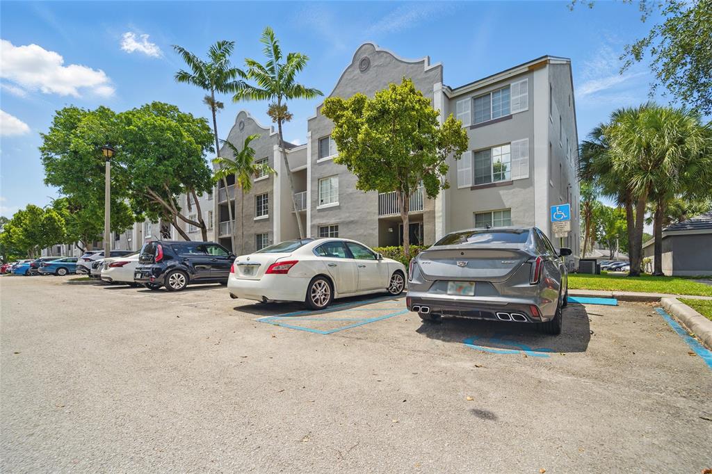 11133 Southwest 8th Street, Unit 306 Pembroke Pines, FL 33025 - Photo 2 of 14 a view of a cars parked in front of a building