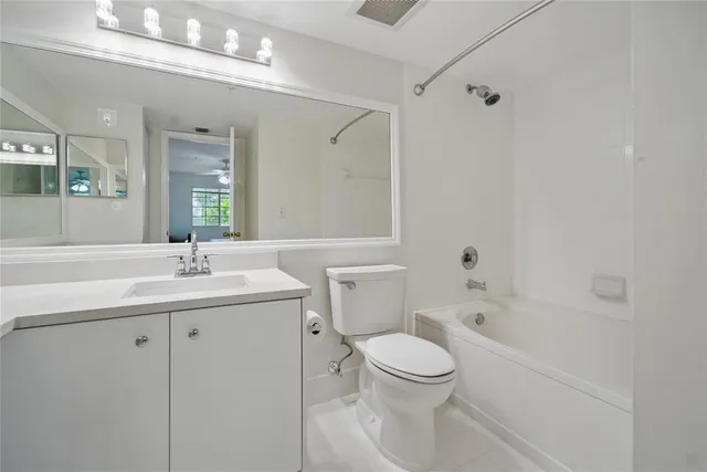a bathroom with a toilet a sink a mirror a bathtub and vanity