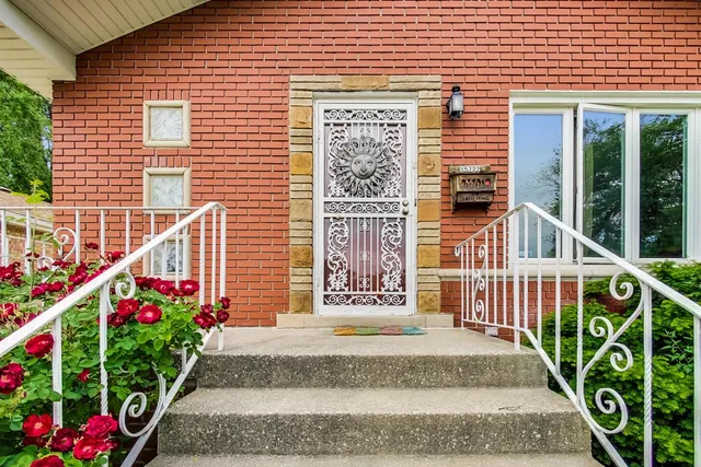 a view of a house with a small yard and flower plants