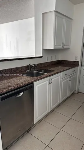 a kitchen with a sink a stove and cabinets